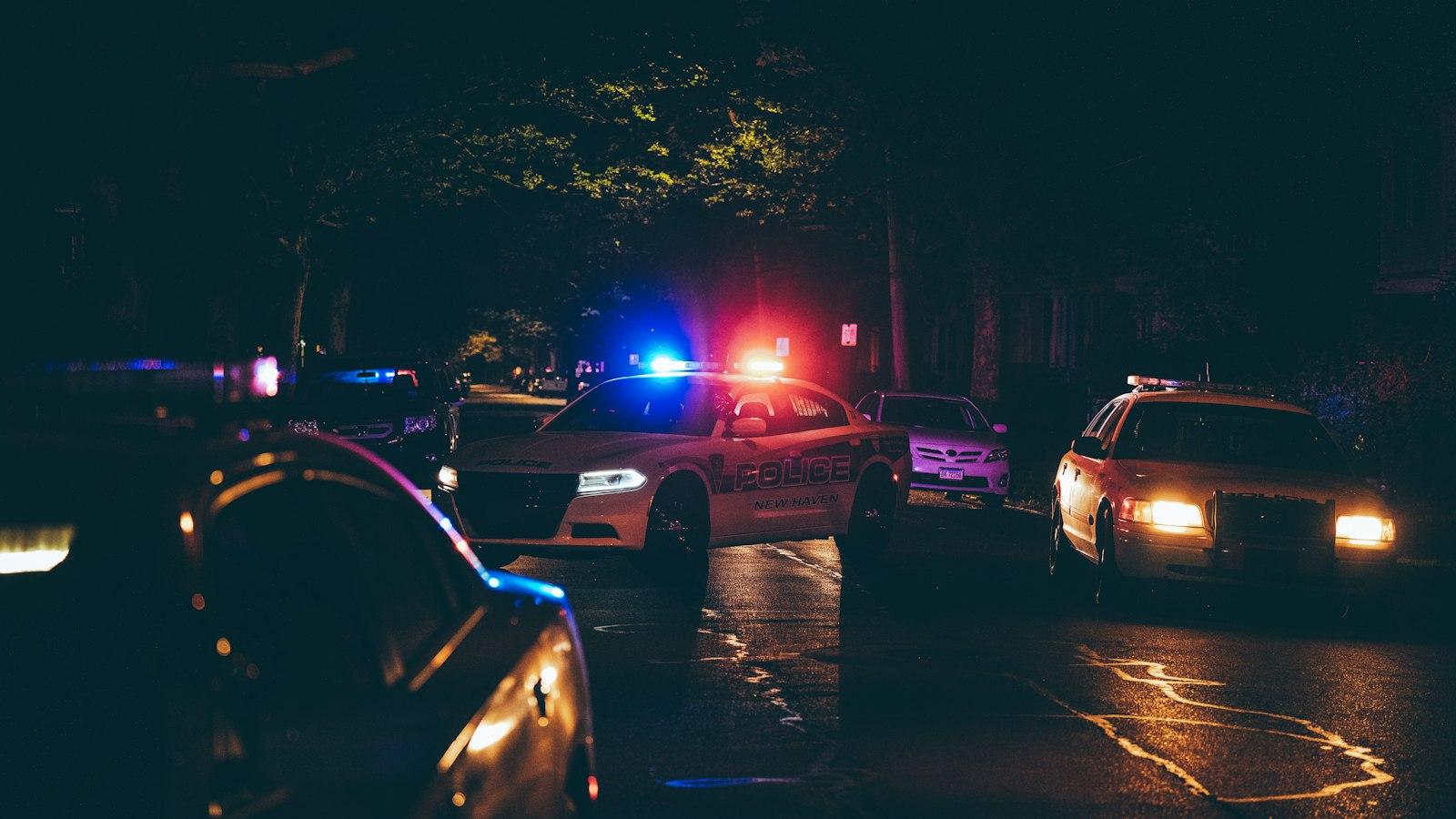 Police vehicles with lights on at a night scene