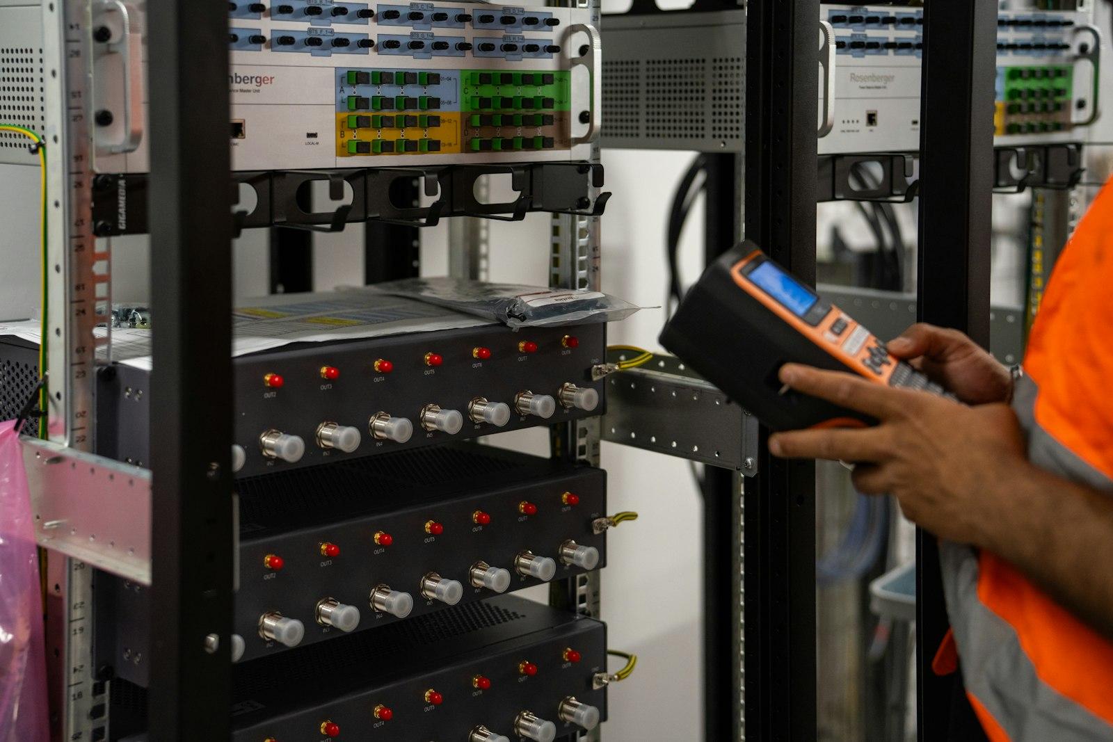 Technician checking server racks with a handheld device